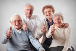 Elderly people with their thumbs up.
