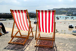 Two empty deckchairs on the sea front, St. Ives, UK.