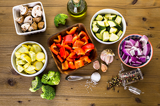 Fresh ingredients for preparing roasted mixed vegetables on the table.