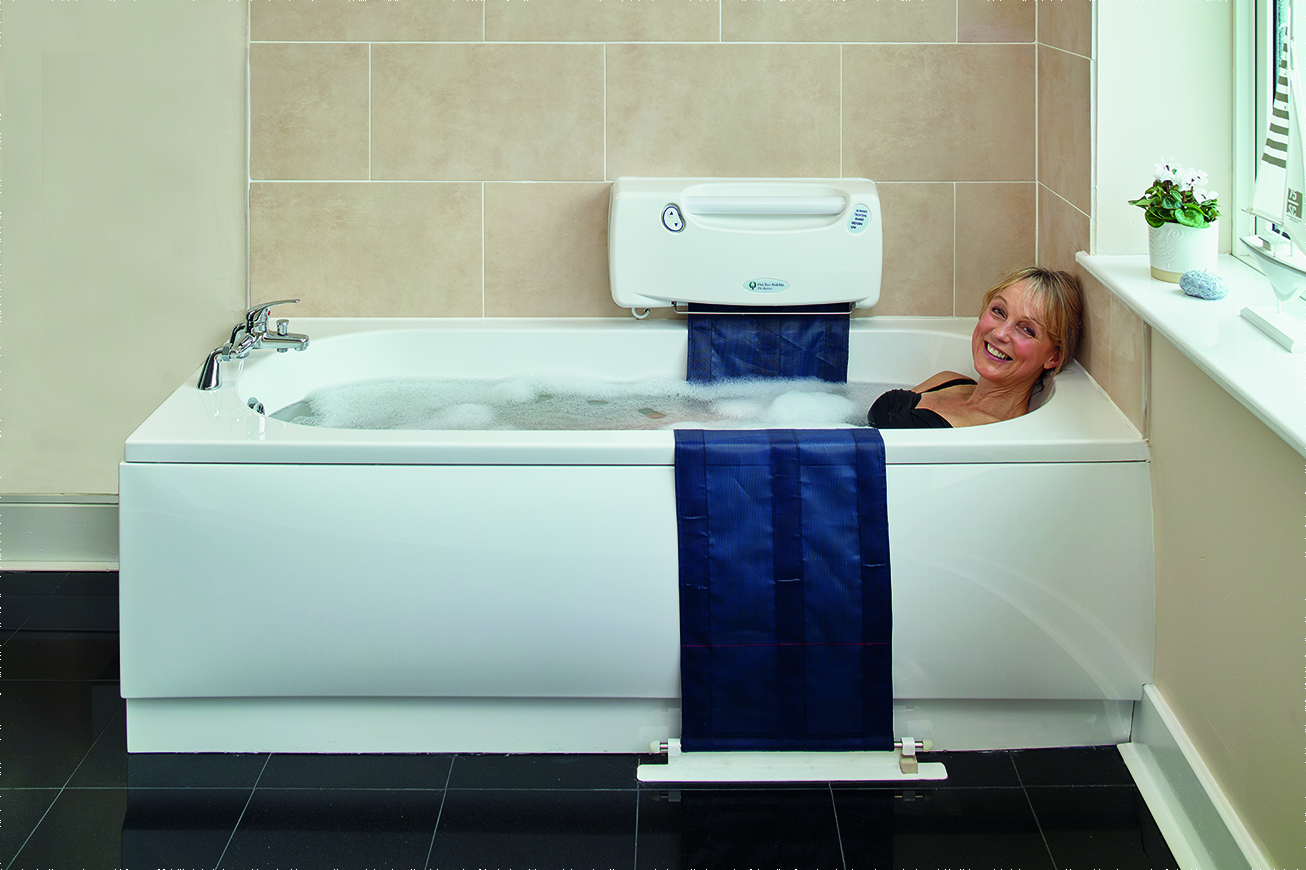 Woman relaxes in a bath with an Oak Tree Mobility bath lift