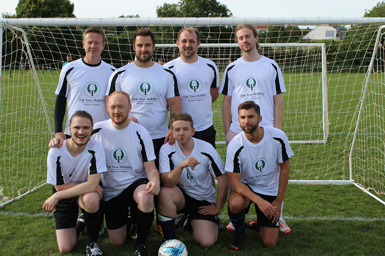 Oak Tree Mobility team members in front of a football goal