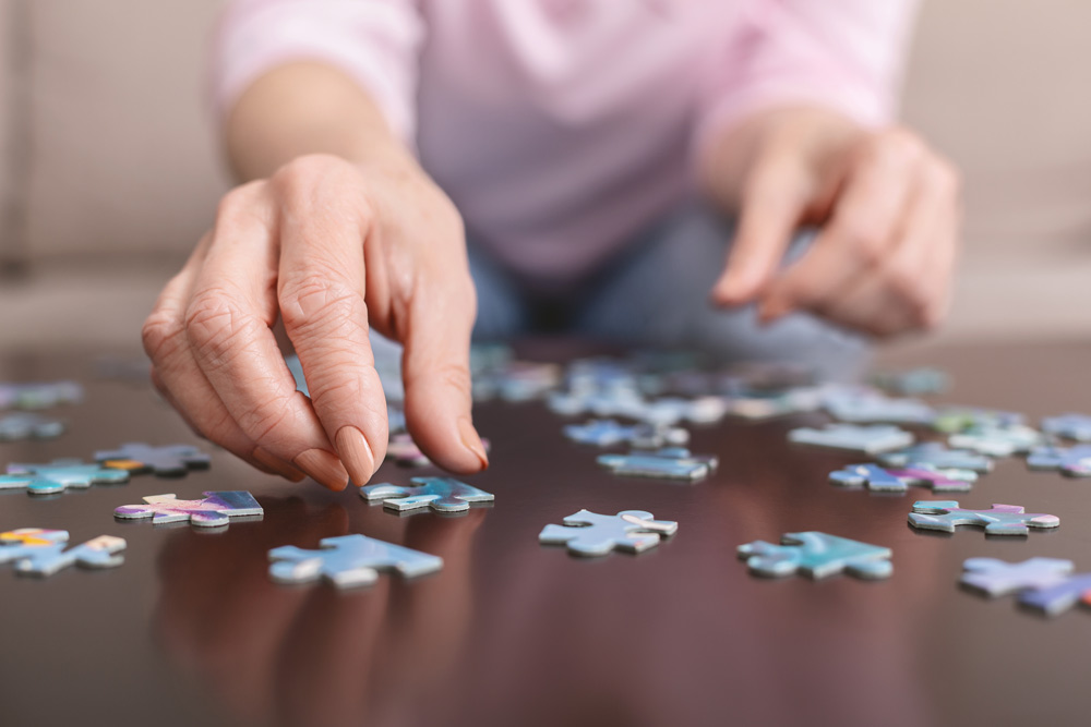 Elderly woman with dementia doing a puzzle.