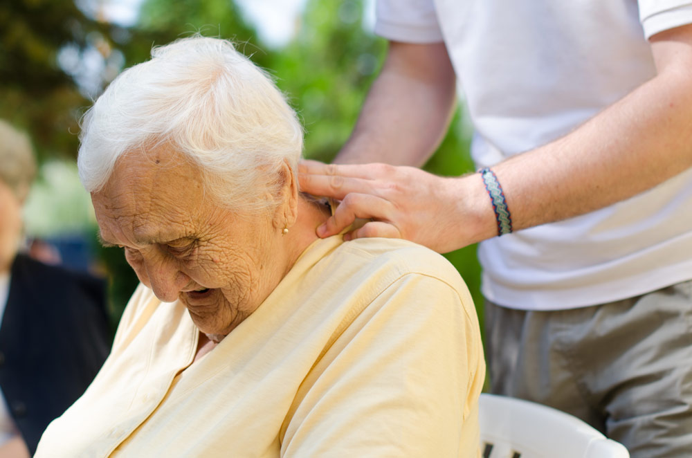 Old woman receiving a neck massage