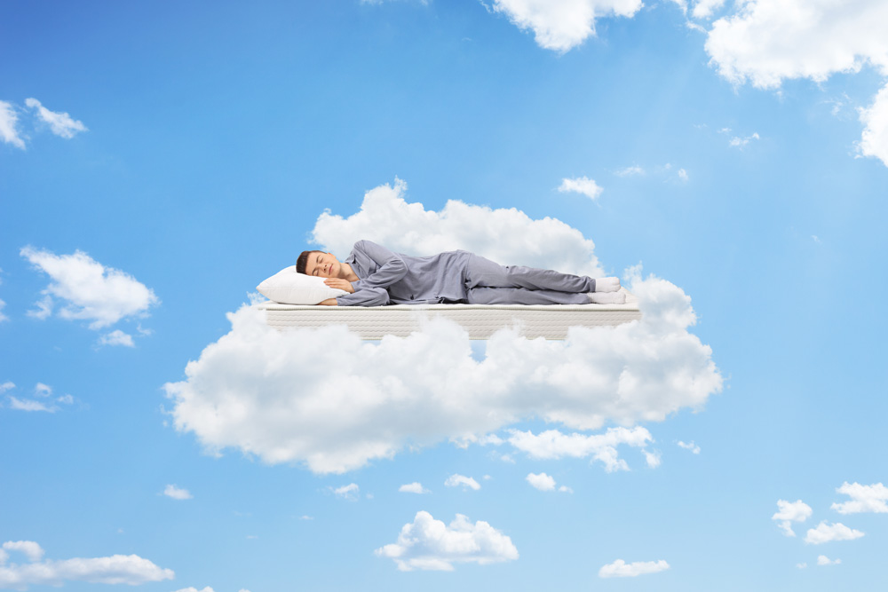 A man relaxing on a mattress in the clouds