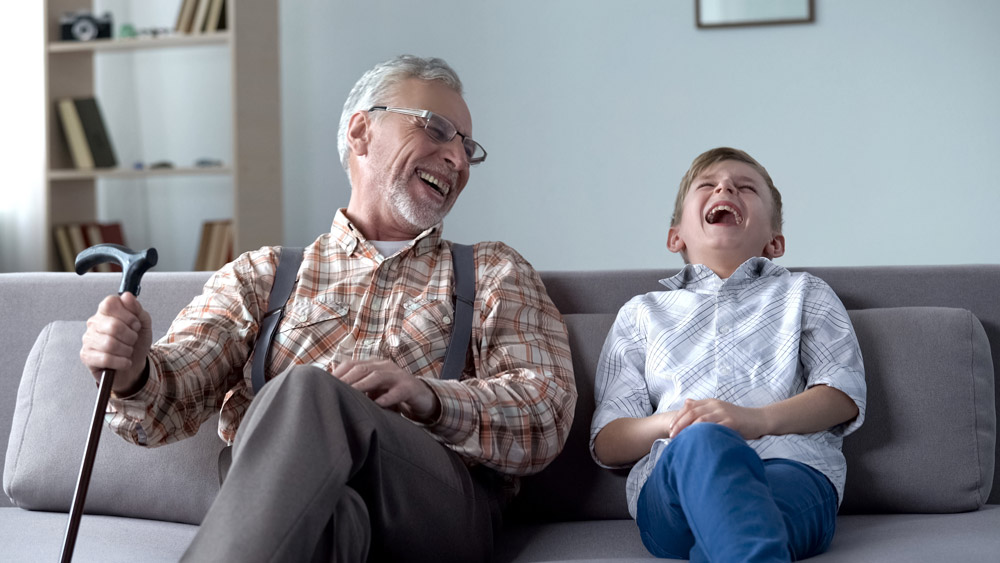 Elderly man laughing and spending time with his grandson to relieve stress