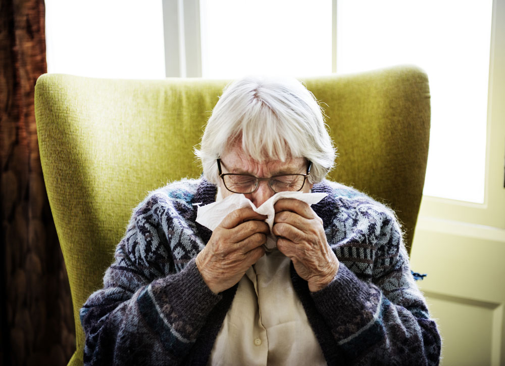 Elderly woman sneezing